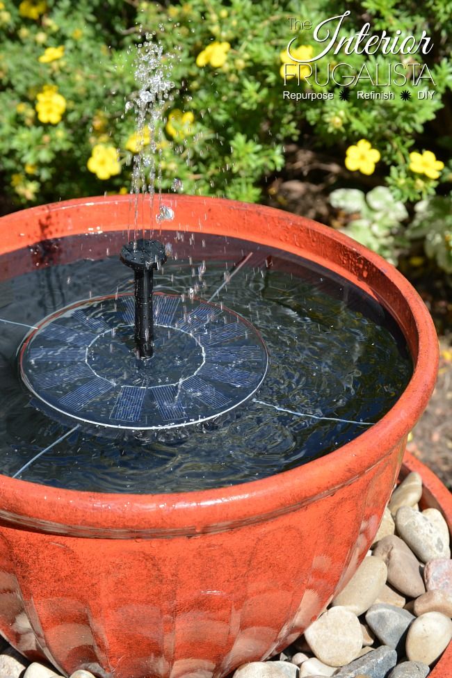 an orange planter filled with water and rocks