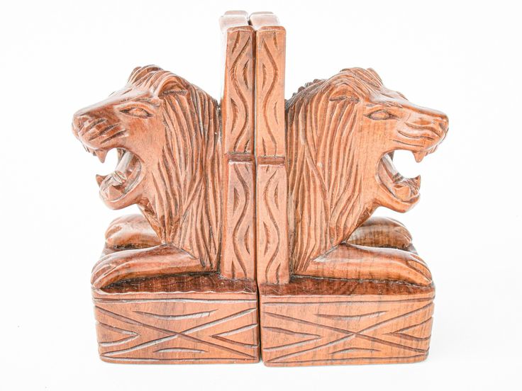 two carved wooden bears sitting on top of each other in front of a white background