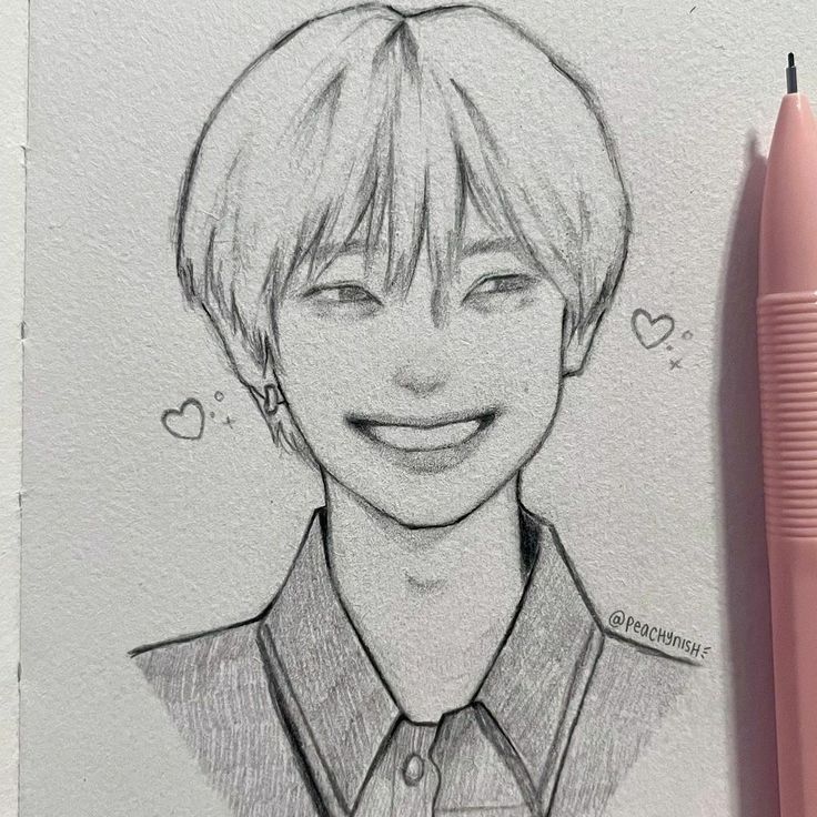 a pencil drawing of a smiling boy with his eyes closed and tongue out, next to a pink pen