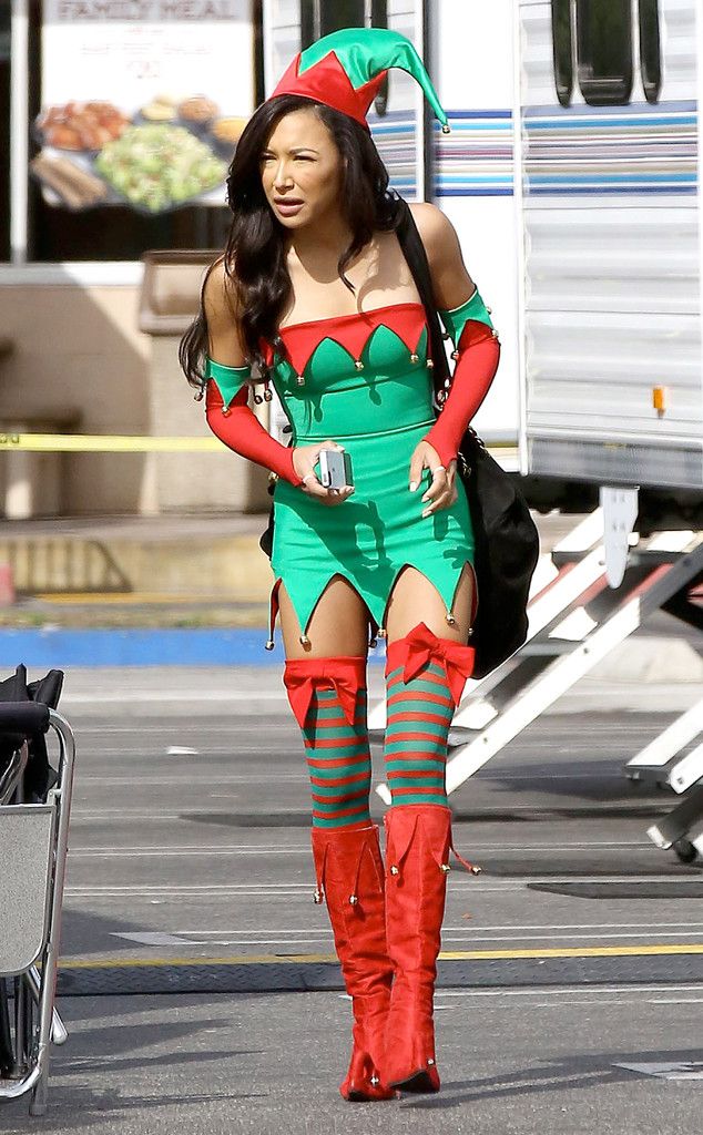 a woman in a costume is walking down the street with her hand on her hip