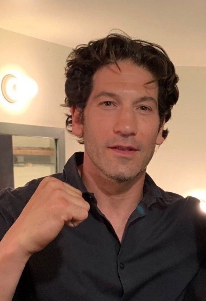 a man in a black shirt is brushing his teeth