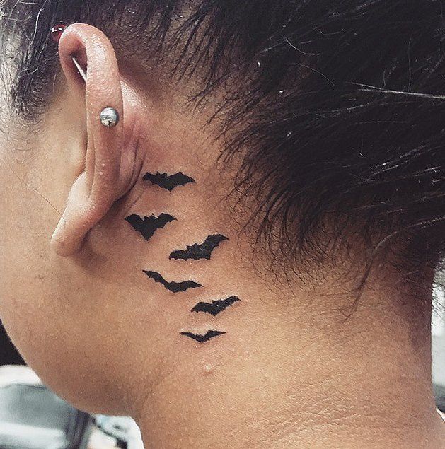 a woman's behind the ear tattoo with bats