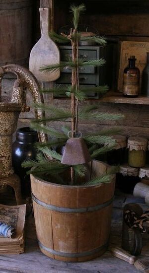 a potted plant sitting on top of a wooden barrel next to other pots and containers