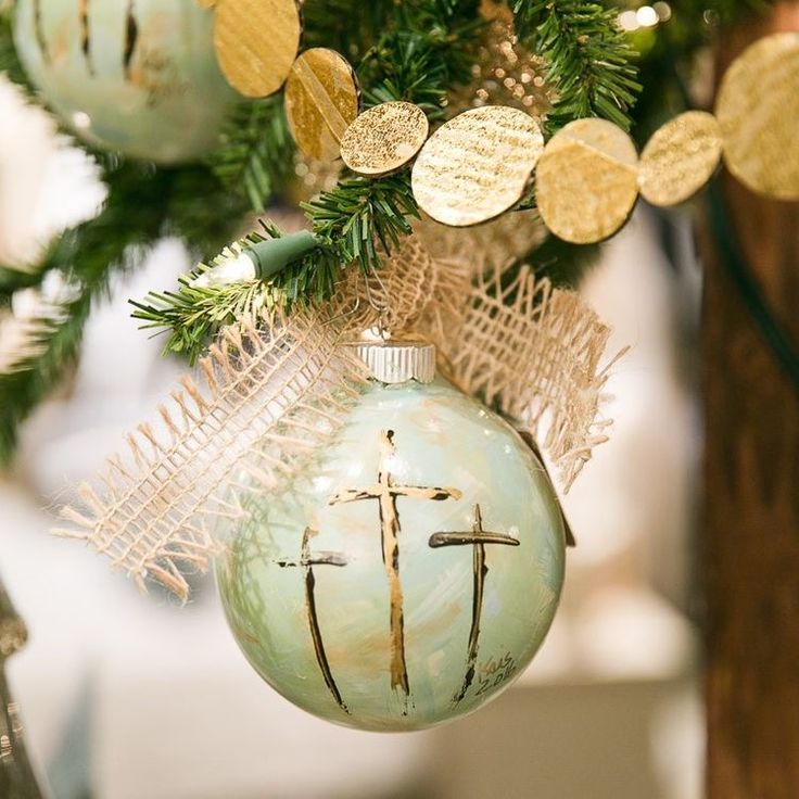 an ornament hanging from a christmas tree decorated with gold and silver ornaments,