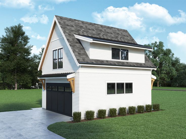 a white house with a black garage door and windows on the front, surrounded by green grass