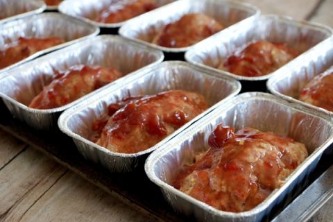 several tins filled with food sitting on top of a wooden table