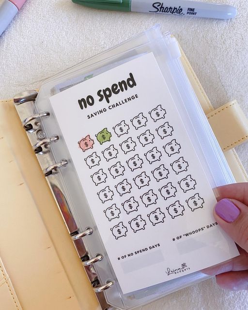 a hand holding a binder with some writing on it and another pen next to it