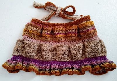 a crocheted skirt hanging on a wall with a knot at the top and bottom