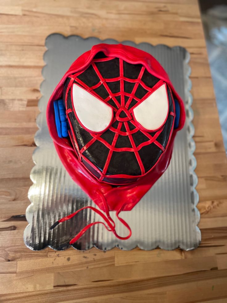 a spiderman cake on top of a wooden table