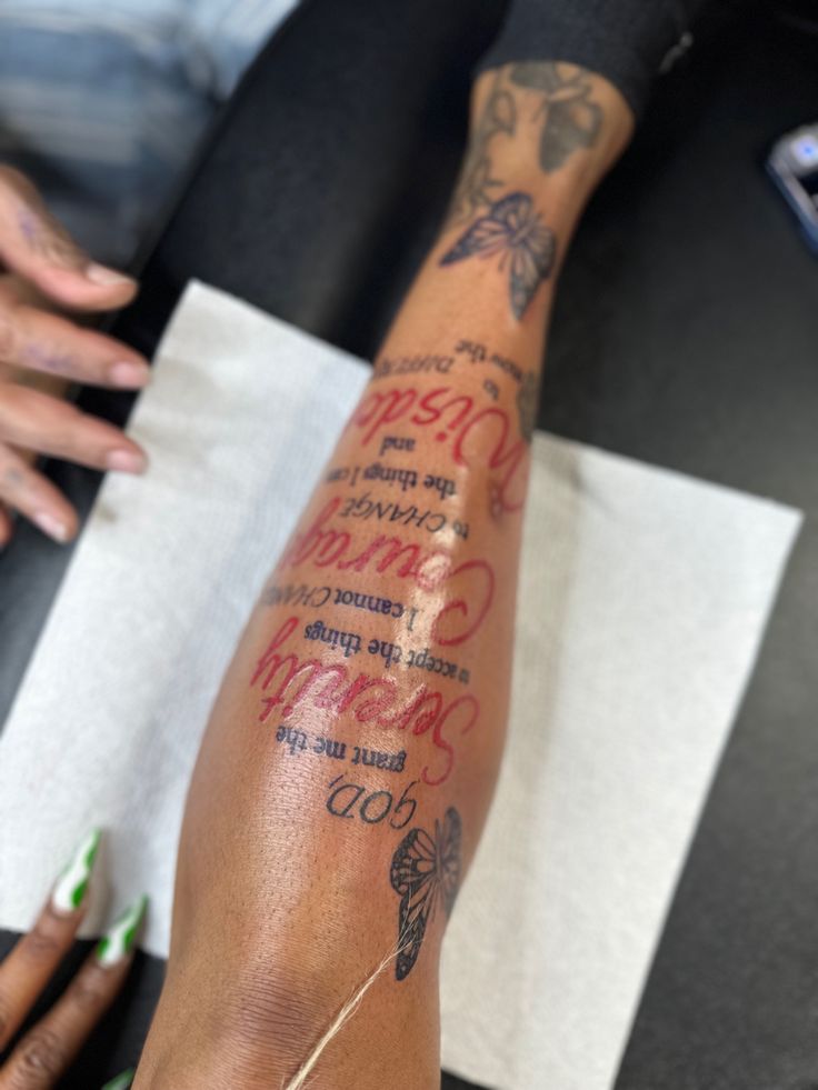 a woman with tattoos on her arm and leg is holding a piece of paper that has writing on it