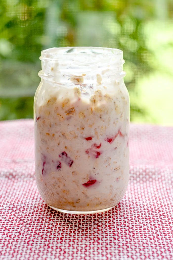 a jar filled with oatmeal sitting on top of a red and white checkered table cloth