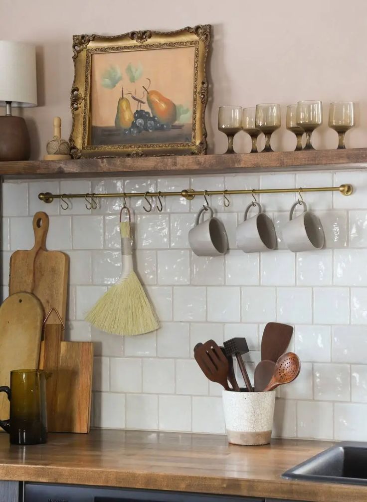 a kitchen counter with pots and pans hanging on the wall next to utensils