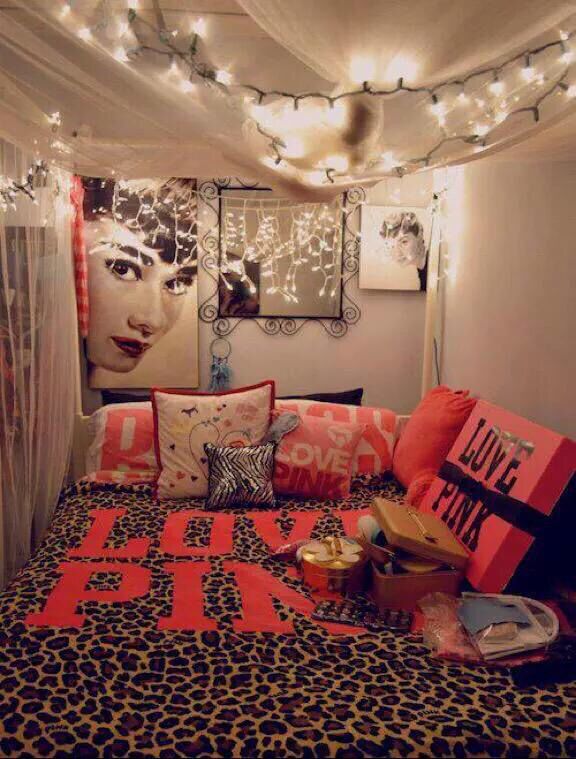 a bed room with a neatly made bed and pictures on the wall above it at night