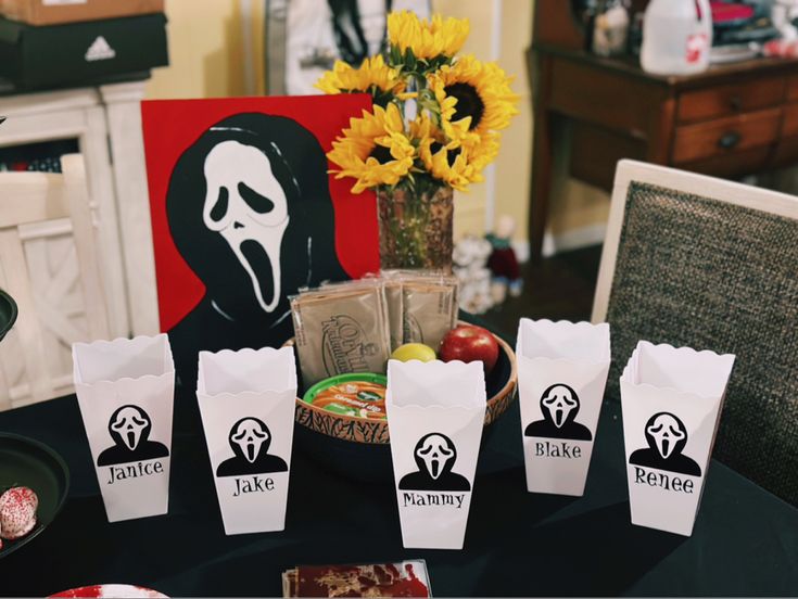 halloween treat bags sitting on top of a table with candy in front of them and an image of a person's face