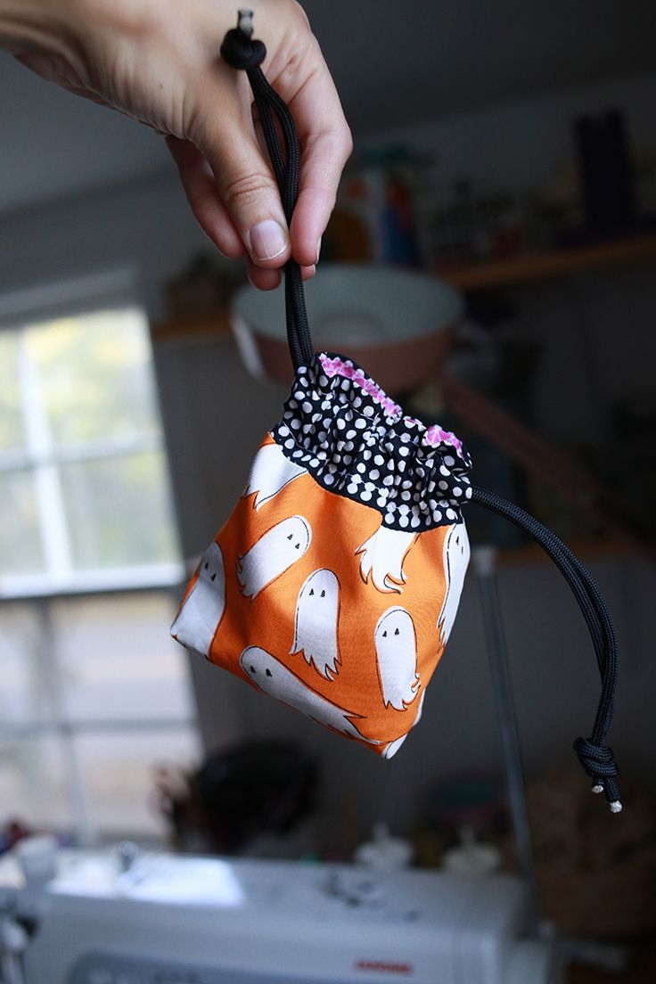 a hand holding an orange and white trick bag