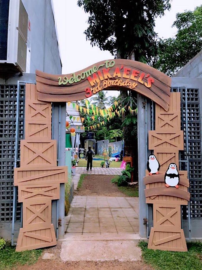 the entrance to an amusement park is decorated with wooden carvings and penguins on it's sides