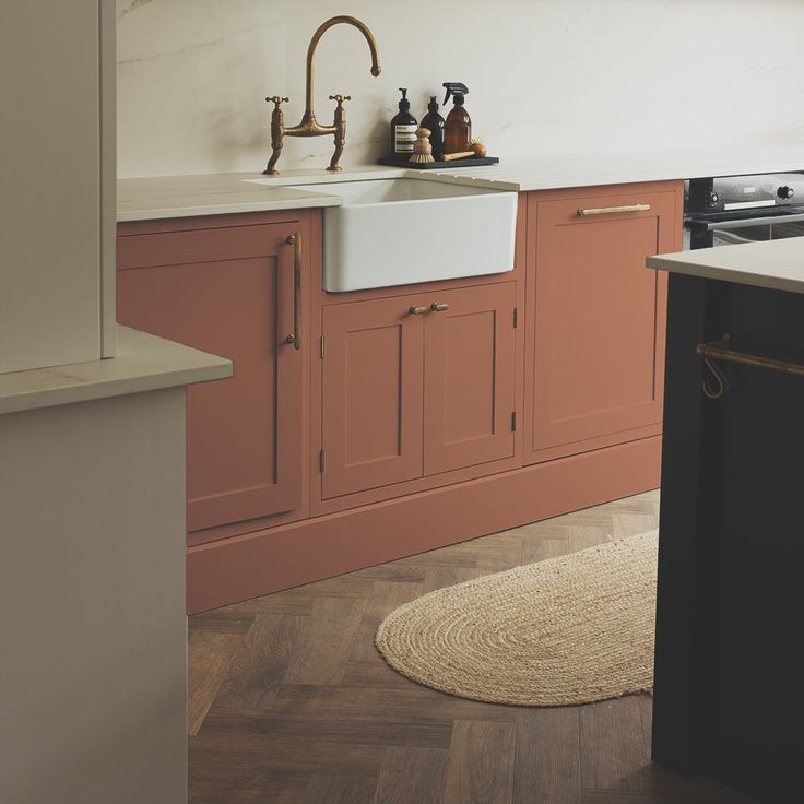 a kitchen with white cabinets and wood floors, including a sink in the center area