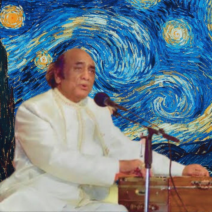 a man sitting in front of a microphone on top of a wooden table next to a painting