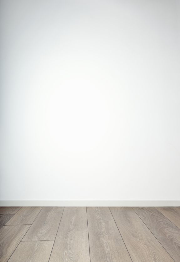 an empty room with wood floors and white walls is seen in this image from the side