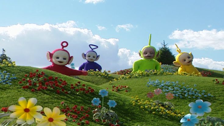 three monkeys sitting on top of a lush green hillside covered in flowers and daisies