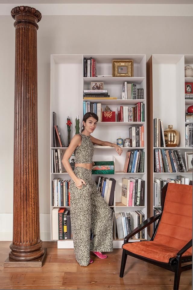 a woman standing in front of a book shelf