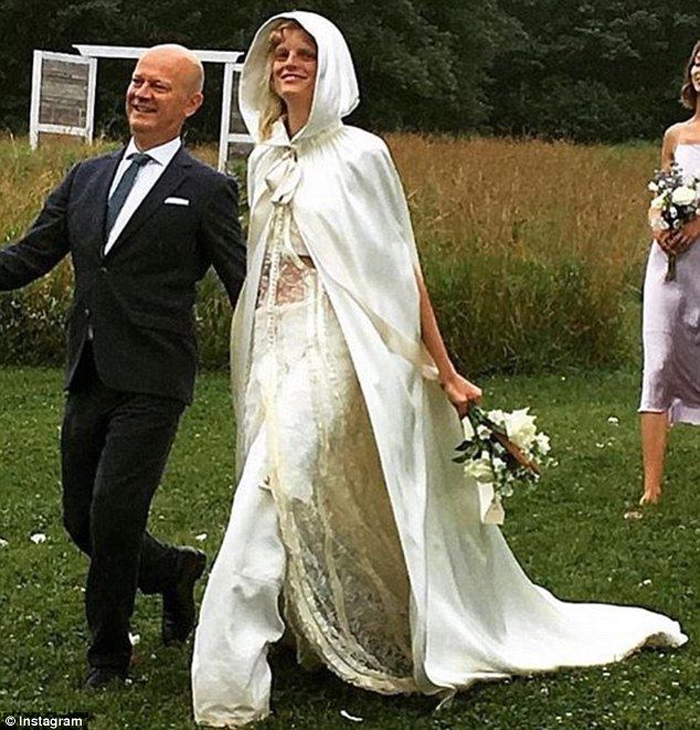 a bride and groom walking through the grass