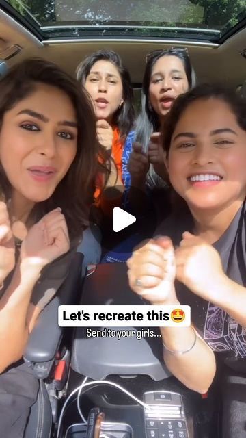 group of young women sitting in the back of a car giving thumbs up and smiling