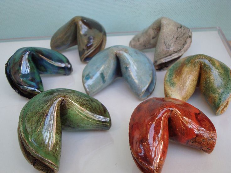 five different colored ceramic objects sitting on top of a white surface, one is shaped like an elephant's head