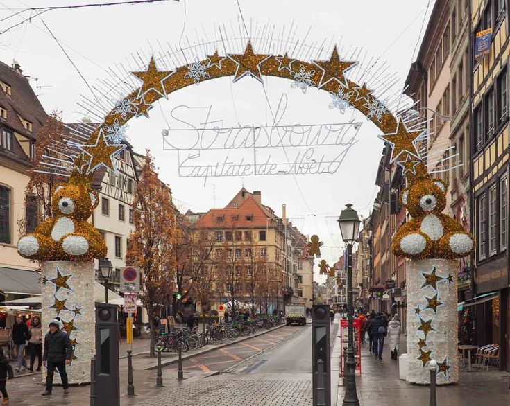 an arch decorated with christmas decorations on a city street