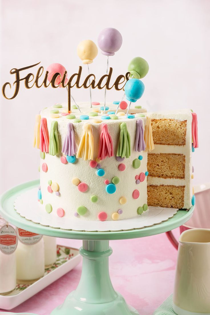 a birthday cake with the word feliquade on top and balloons above it