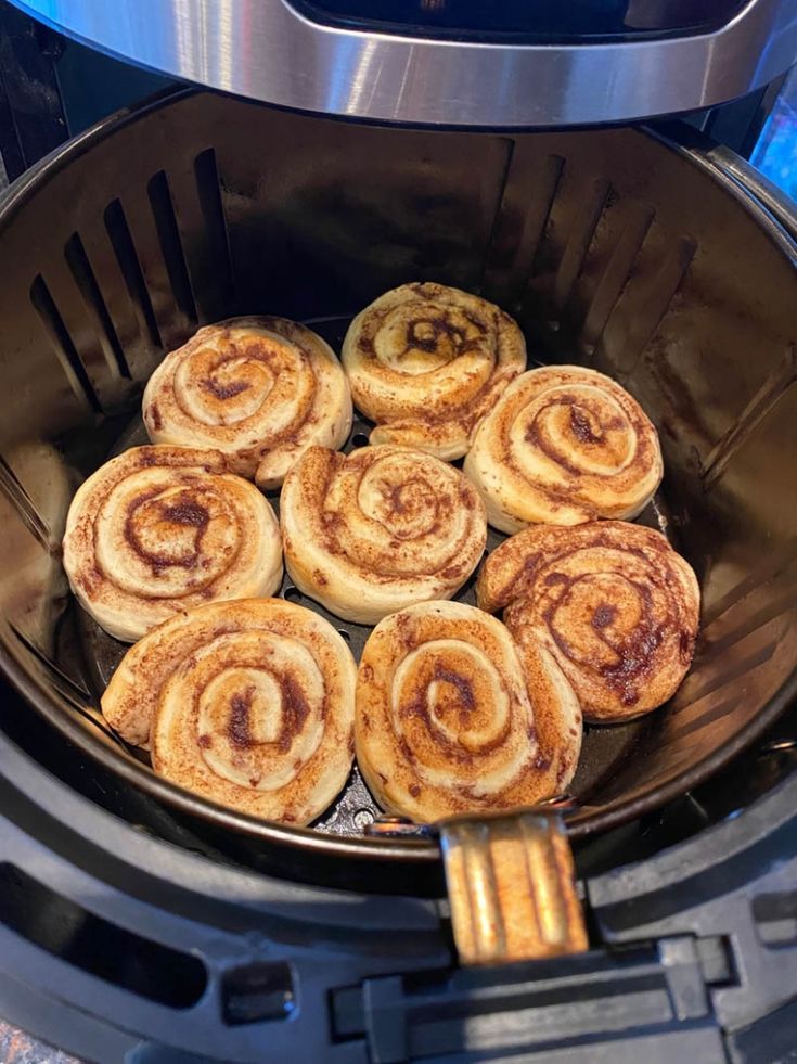 some cinnamon rolls are in the air fryer and ready to be cooked for dinner