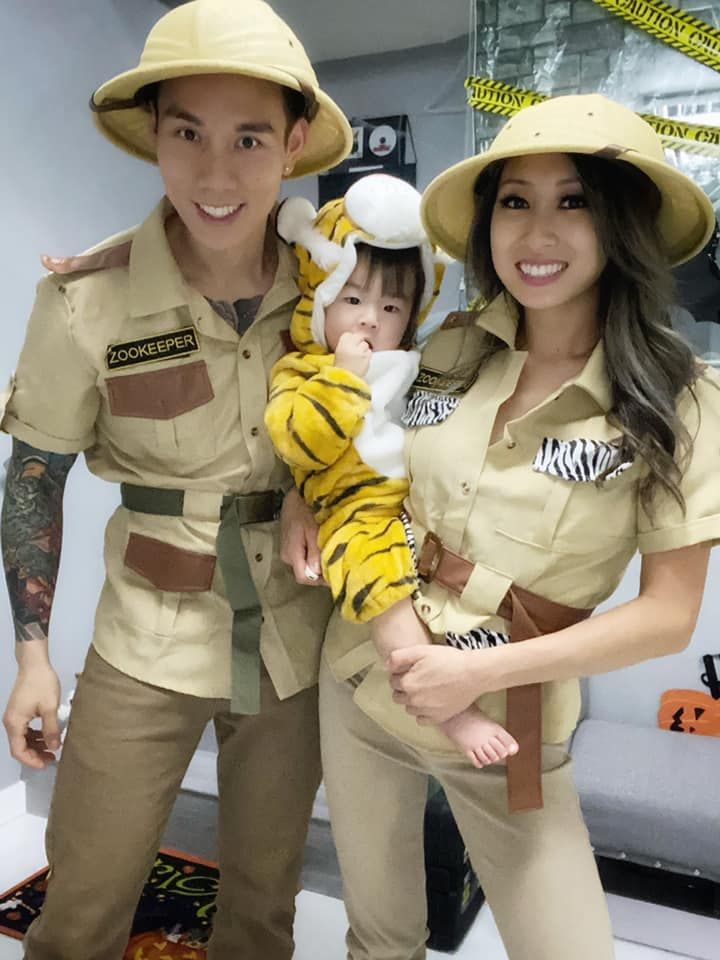 a man and woman in safari costumes holding a baby