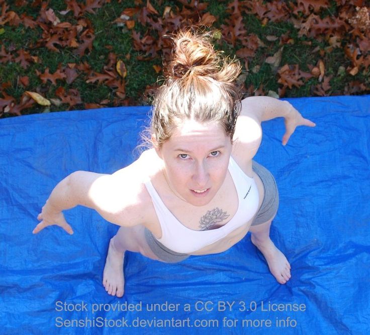 a woman laying on top of a blue tarp with her arms spread out in the air