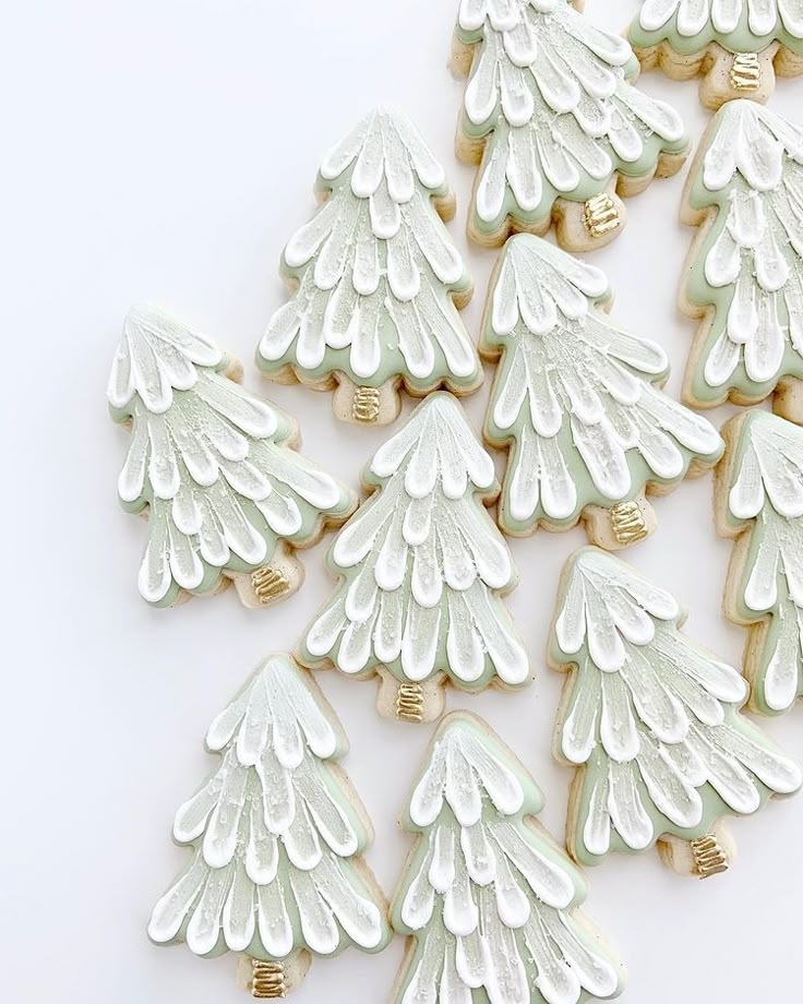 decorated cookies with white frosting and gold trimmings in the shape of christmas trees