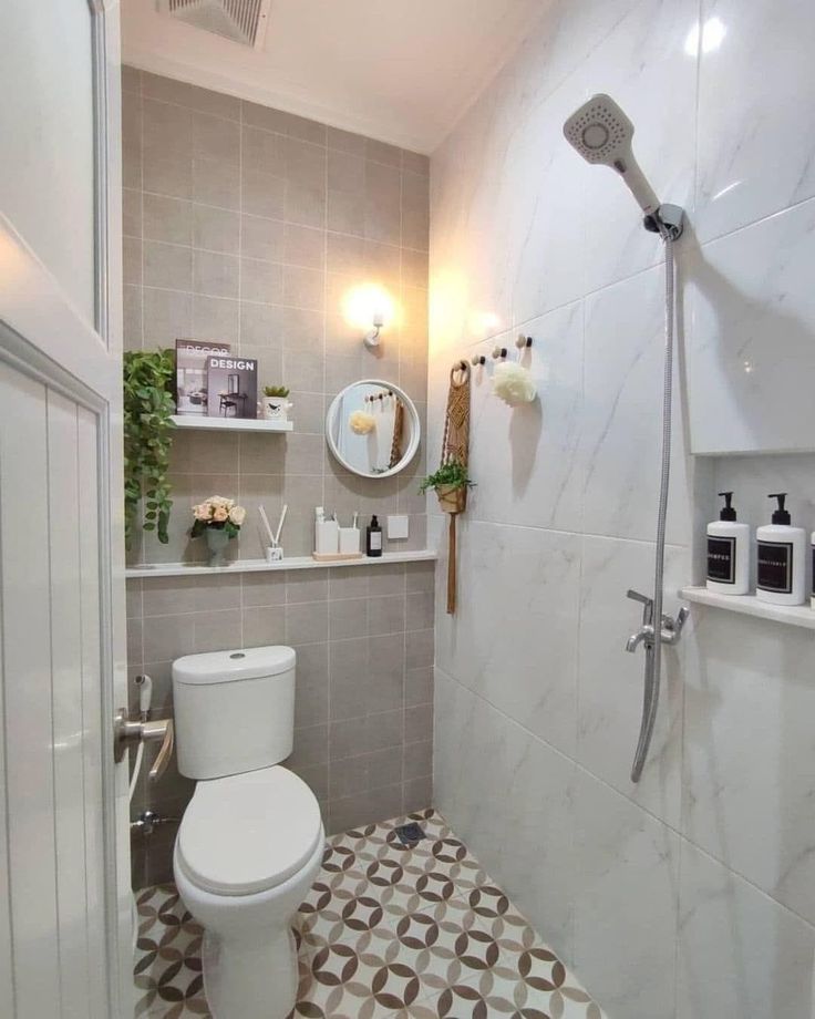 a white toilet sitting in a bathroom next to a shower