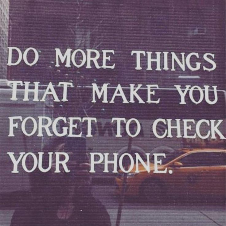 a person standing on the sidewalk with a cell phone in their hand and a sign that says do more things that make you forget to check your phone