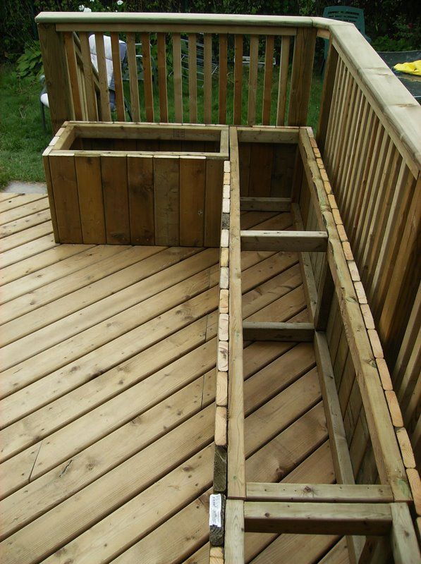 the bottom half of a wooden bench on a deck with measurements in front of it