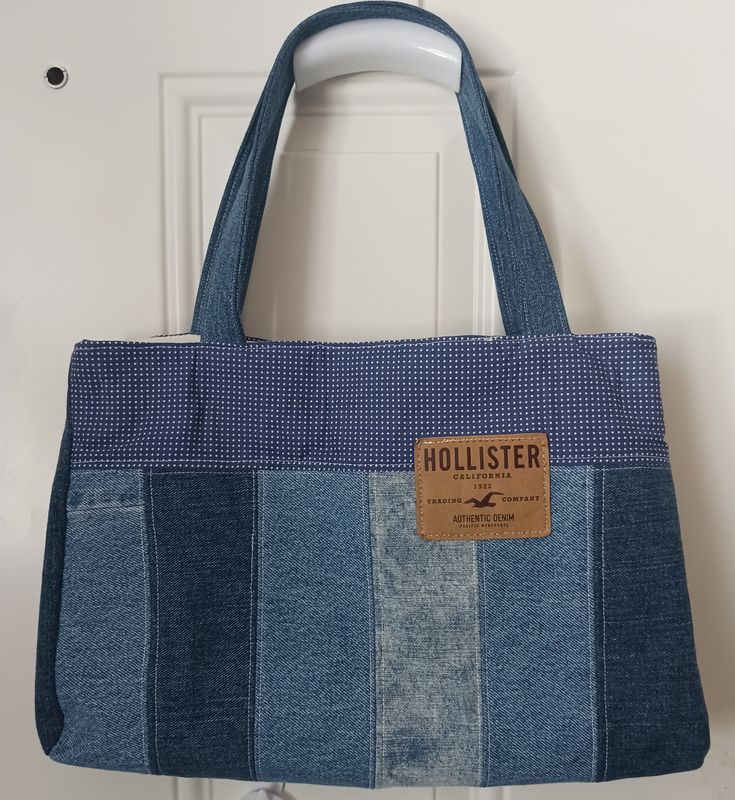 a blue and white striped bag hanging from a hook on a door handle with a tag that says holliester