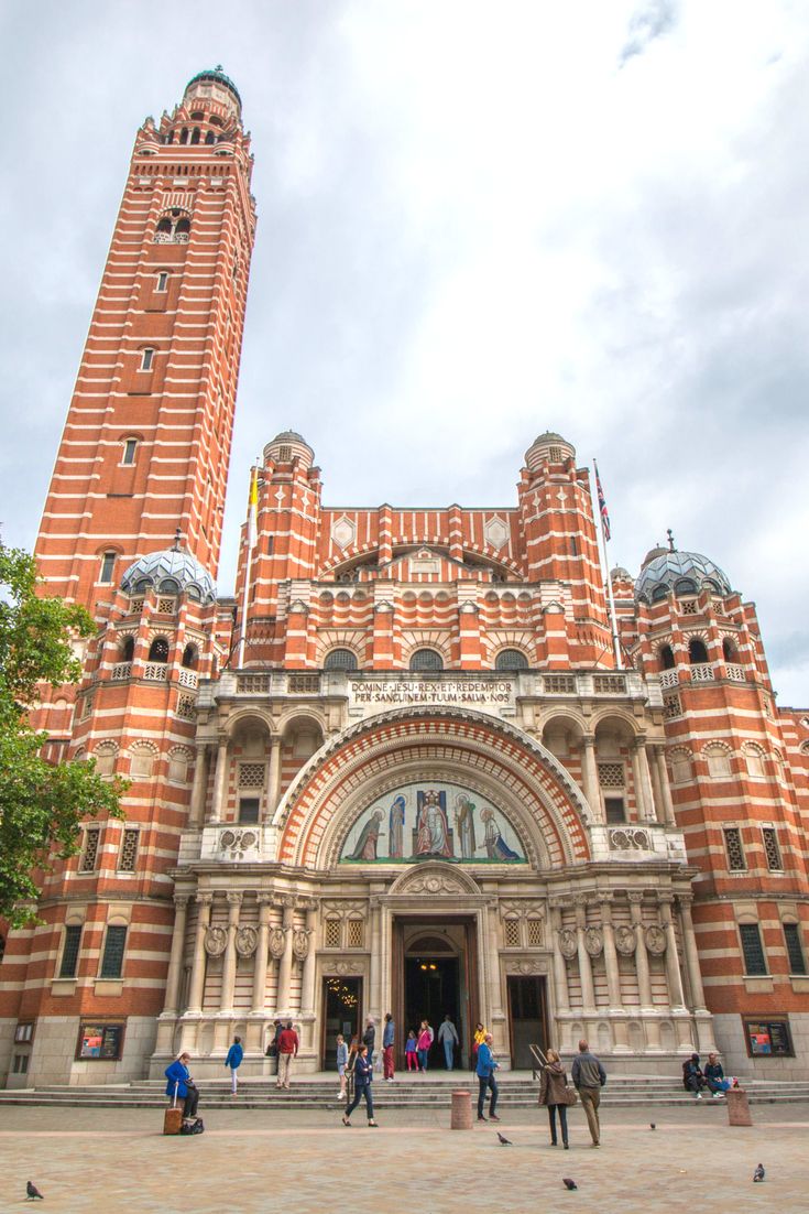 people are standing in front of a large building with two tall towers on each side