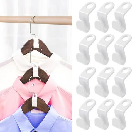 clothes hangers are hanging on a rack with white clips and one has a pink shirt in it