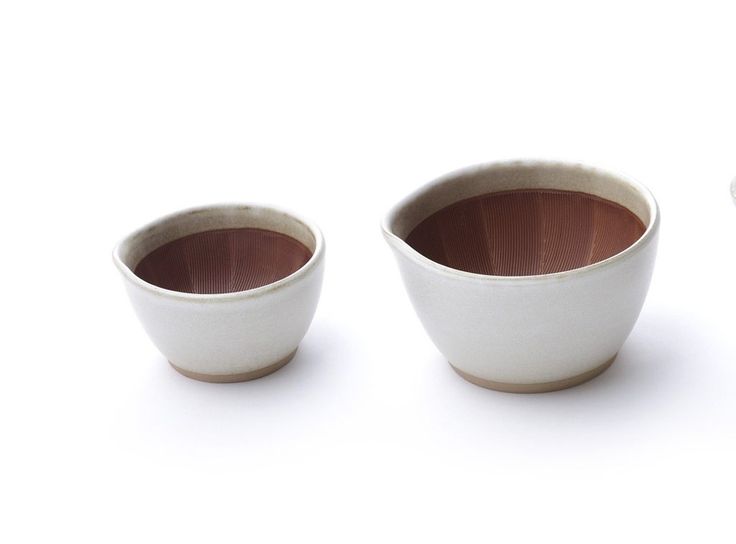 three white bowls with brown rims sitting next to each other on a white surface