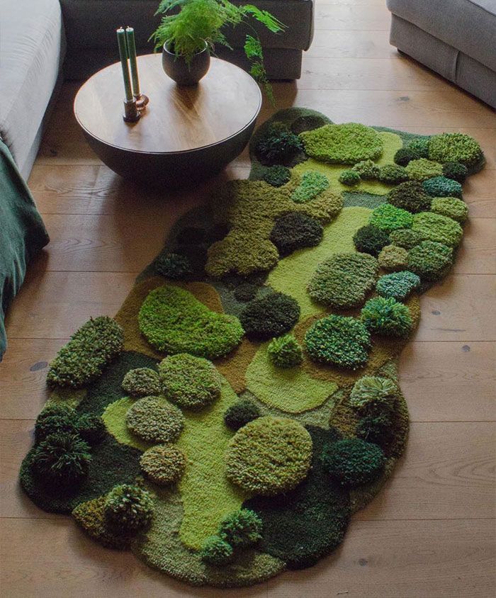 a living room with a rug made out of green plants on the floor next to a couch