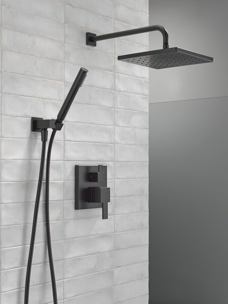 a shower head with thermostaer and hand held shower faucet in front of a white tiled wall