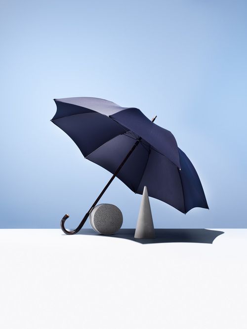 an umbrella and ball sitting on top of a white surface with a blue sky in the background