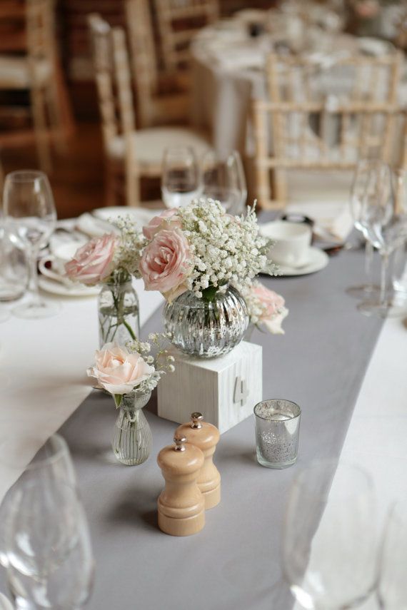 the table is set with flowers in vases