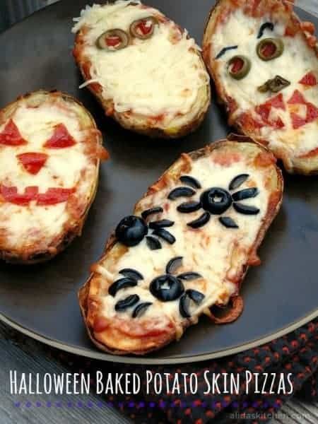 four baked pizzas with faces on them sitting on a black plate and the words halloween baked potato skin pizzas