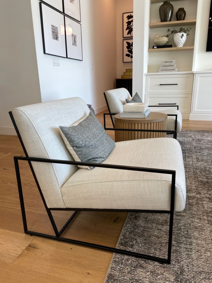 a living room filled with furniture and pictures on the wall next to a rug covered floor