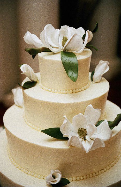 a three tiered wedding cake with white flowers on top