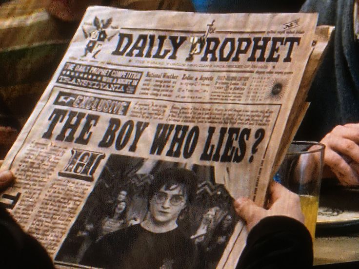 a newspaper with an image of the boy who lies on it being held by two people