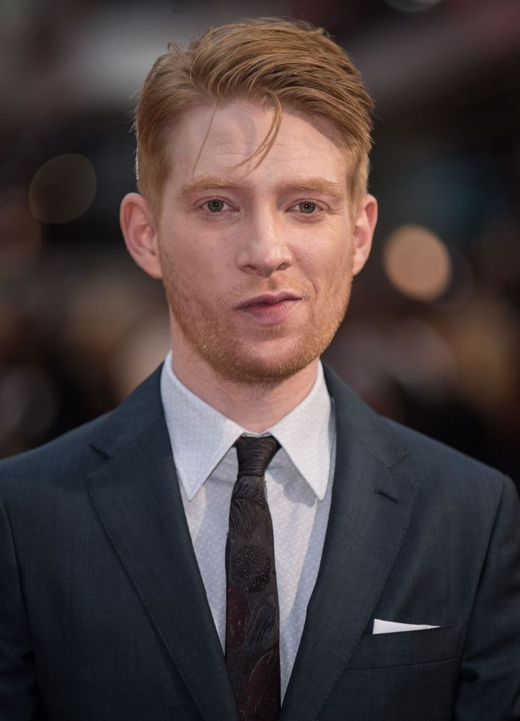 a young man in a suit and tie looking at the camera with serious expression on his face